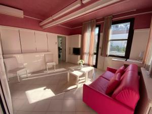 een woonkamer met een rode bank en een tafel bij Villetta Trieste-Flexrent Abissinia in Riccione