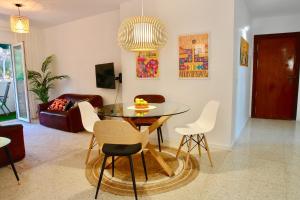 a living room with a glass table and white chairs at Large appartement with great views in Málaga