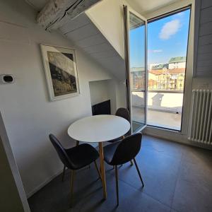 - une table et des chaises dans une chambre avec fenêtre dans l'établissement heart of milan Apartment, à Milan