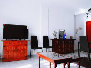 a living room with a tv and a table and chairs at Magnífico ático frente al mar en Ricón de la Victoria in Rincón de la Victoria