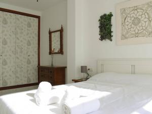 a bedroom with a white bed and a mirror at Magnífico ático frente al mar en Ricón de la Victoria in Rincón de la Victoria