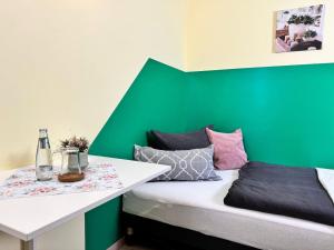 a room with a green accent wall and a bed at Pension am Plan in Herzberg
