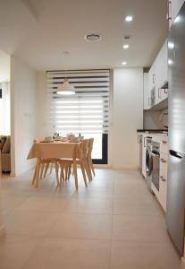 cocina y comedor con mesa y sillas en Amalia's Home: Luminoso apartamento muy cerca de la playa, en Málaga