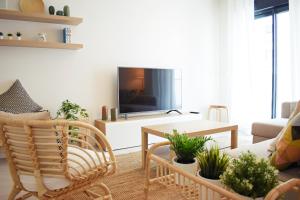 sala de estar con sofá y TV en Amalia's Home: Luminoso apartamento muy cerca de la playa, en Málaga