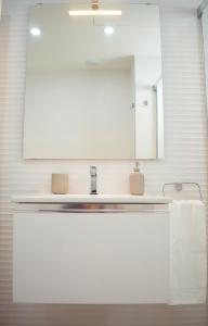 y baño con lavabo y espejo. en Amalia's Home: Luminoso apartamento muy cerca de la playa, en Málaga