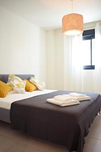 1 dormitorio con 1 cama con 2 toallas en Amalia's Home: Luminoso apartamento muy cerca de la playa, en Málaga
