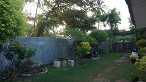 a garden with a fence and a bench in the yard at The Whitegates Lodge in Weligama