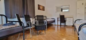 Cette chambre comprend 4 lits, une table et des chaises. dans l'établissement Haus Mitterfeld, à Kasten bei Böheimkirchen