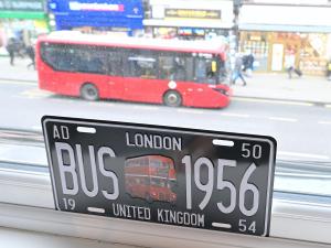 una matrícula con un autobús rojo en una calle en 1 BEDROOM FLAT IN WOOD GREEN PICCADILLY LINE, en Londres