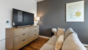 ein Wohnzimmer mit einem Sofa und einem Flachbild-TV in der Unterkunft Landing Modern Apartment with Amazing Amenities (ID7082X14) in Portland