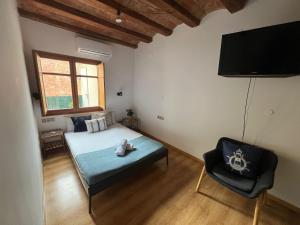 - une chambre avec un lit, une télévision et une chaise dans l'établissement Apartments near Ramblas - Only for stays over 32 days, à Barcelone