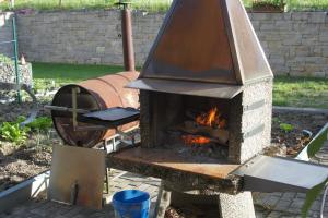 un horno de ladrillo con parrilla en un jardín en Beat & Ursula's Guest House en Jenaz
