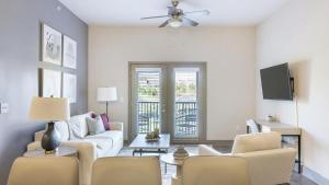 un soggiorno con mobili bianchi e ventilatore a soffitto di Landing - Modern Apartment with Amazing Amenities (ID9024X45) a Spring Hill