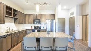 una cucina con tavolo, sedie e frigorifero di Landing - Modern Apartment with Amazing Amenities (ID9024X45) a Spring Hill