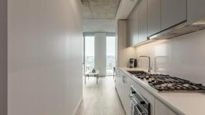 a kitchen with white cabinets and a stove top oven at Landing - Modern Apartment with Amazing Amenities (ID5157X18) in Portland