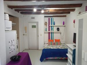 Una pequeña habitación con una cama y una mesa morada. en Estudio con balcon Plaza España, en Barcelona