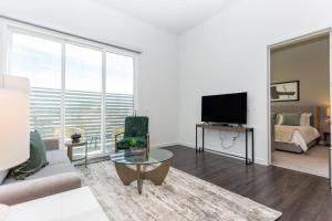 a living room with a couch and a tv at Landing - Modern Apartment with Amazing Amenities (ID3121X08) in Las Vegas