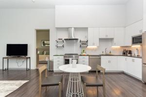 a white kitchen with a table and chairs in it at Landing - Modern Apartment with Amazing Amenities (ID3121X08) in Las Vegas