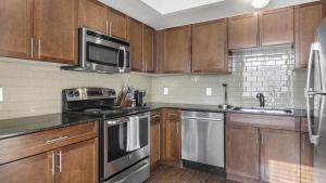 eine Küche mit Holzschränken und Küchengeräten aus Edelstahl in der Unterkunft Landing - Modern Apartment with Amazing Amenities (ID8814) in Boulder