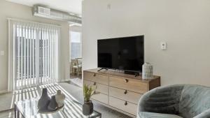 ein Wohnzimmer mit einem Flachbild-TV auf einer Kommode in der Unterkunft Landing - Modern Apartment with Amazing Amenities (ID8814) in Boulder