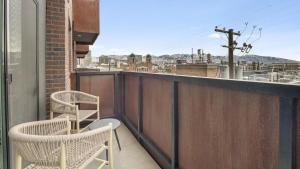 a balcony with two chairs and a view of a city at Landing - Modern Apartment with Amazing Amenities (ID7703X6) in Salt Lake City
