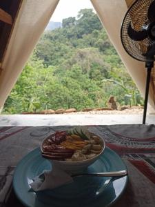 uma tigela de comida num prato numa mesa em tukamping em Minca