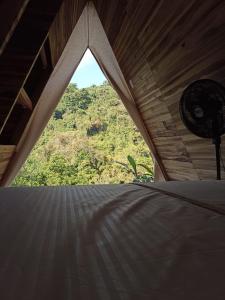 ventana en una habitación con vistas a la montaña en tukamping, en Minca