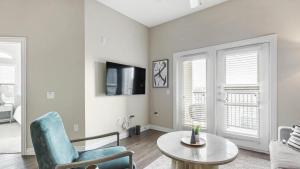 sala de estar con silla azul y mesa en Landing - Modern Apartment with Amazing Amenities (ID3874), en Carrollton