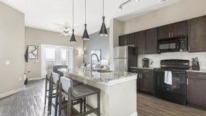 a kitchen with a large island with bar stools at Landing - Modern Apartment with Amazing Amenities (ID3874) in Carrollton