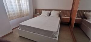 a bedroom with a bed with white sheets and pillows at Ondas Relax House in Praia