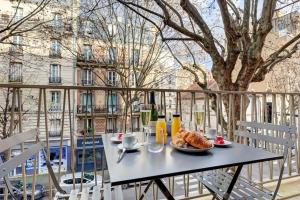 einen Tisch mit einem Teller Essen auf dem Balkon in der Unterkunft 340 Suite Emile - Superb apartment in Clichy