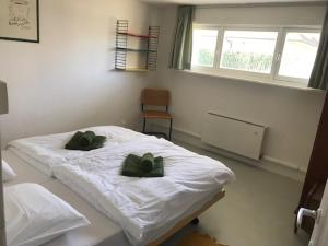 um quarto com uma cama com duas almofadas verdes em Holiday Home Hoge Blekker em Koksijde