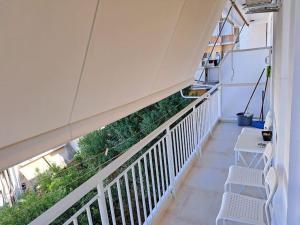 a balcony with two white benches and plants on it at Luxury Suite Patras (2) in Patra