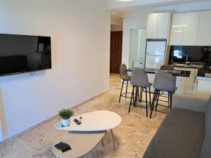 a living room with a tv and a table and chairs at Luxury Suite Patras (2) in Patra