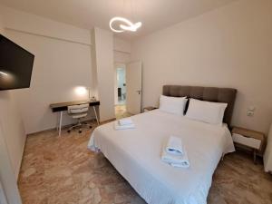 a bedroom with a large white bed and a desk at Luxury Suite Patras (2) in Patra