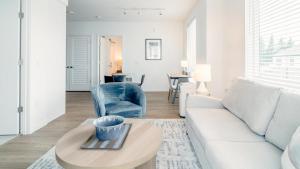 - un salon avec un canapé blanc et une chaise bleue dans l'établissement Landing - Modern Apartment with Amazing Amenities (ID5770X40), à Everett