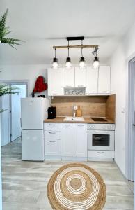 a kitchen with white appliances and a rug on the floor at Bulgarane House in Govedartsi