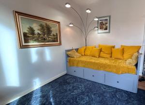 Habitación con sofá y almohadas amarillas. en Le Cosy Family Lourdes, en Lourdes