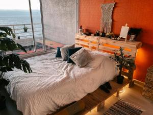 Cama en habitación con ventana grande en Vista panoramica increible en Viña del Mar