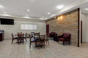 a dining room with tables and chairs and a brick wall at Red Lion Inn & Suites Caseyville in Caseyville