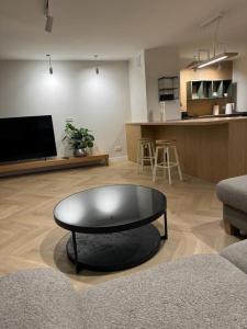 a living room with a coffee table and a kitchen at APARTAMENT OVOC 1.0 in Chodzież