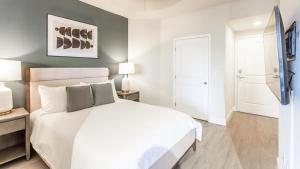 ein Schlafzimmer mit einem weißen Bett und zwei Lampen in der Unterkunft Landing - Modern Apartment with Amazing Amenities (ID8458X06) in Miami