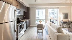 eine Küche und ein Wohnzimmer mit einem Kühlschrank und einem Sofa in der Unterkunft Landing - Modern Apartment with Amazing Amenities (ID8458X06) in Miami