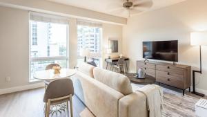 ein Wohnzimmer mit einem Sofa und einem TV in der Unterkunft Landing - Modern Apartment with Amazing Amenities (ID8458X06) in Miami