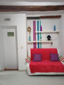 a red couch with two pillows in a room at Estudio con balcon Plaza España in Barcelona