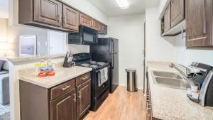 a small kitchen with a stove and a sink at Landing - Modern Apartment with Amazing Amenities (ID2836X91) in Houston