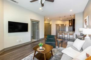 een woonkamer met een bank, een tv en een tafel bij Landing - Modern Apartment with Amazing Amenities (ID2257) in Dallas