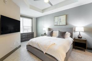 een slaapkamer met een groot bed en een flatscreen-tv bij Landing - Modern Apartment with Amazing Amenities (ID2257) in Dallas