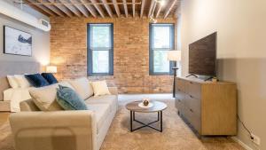 uma sala de estar com um sofá e uma televisão em Landing - Modern Apartment with Amazing Amenities (ID5125X39) em Chicago