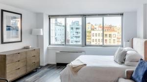 - une chambre blanche avec un lit et une fenêtre dans l'établissement Landing - Modern Apartment with Amazing Amenities (ID5067X83), à New York